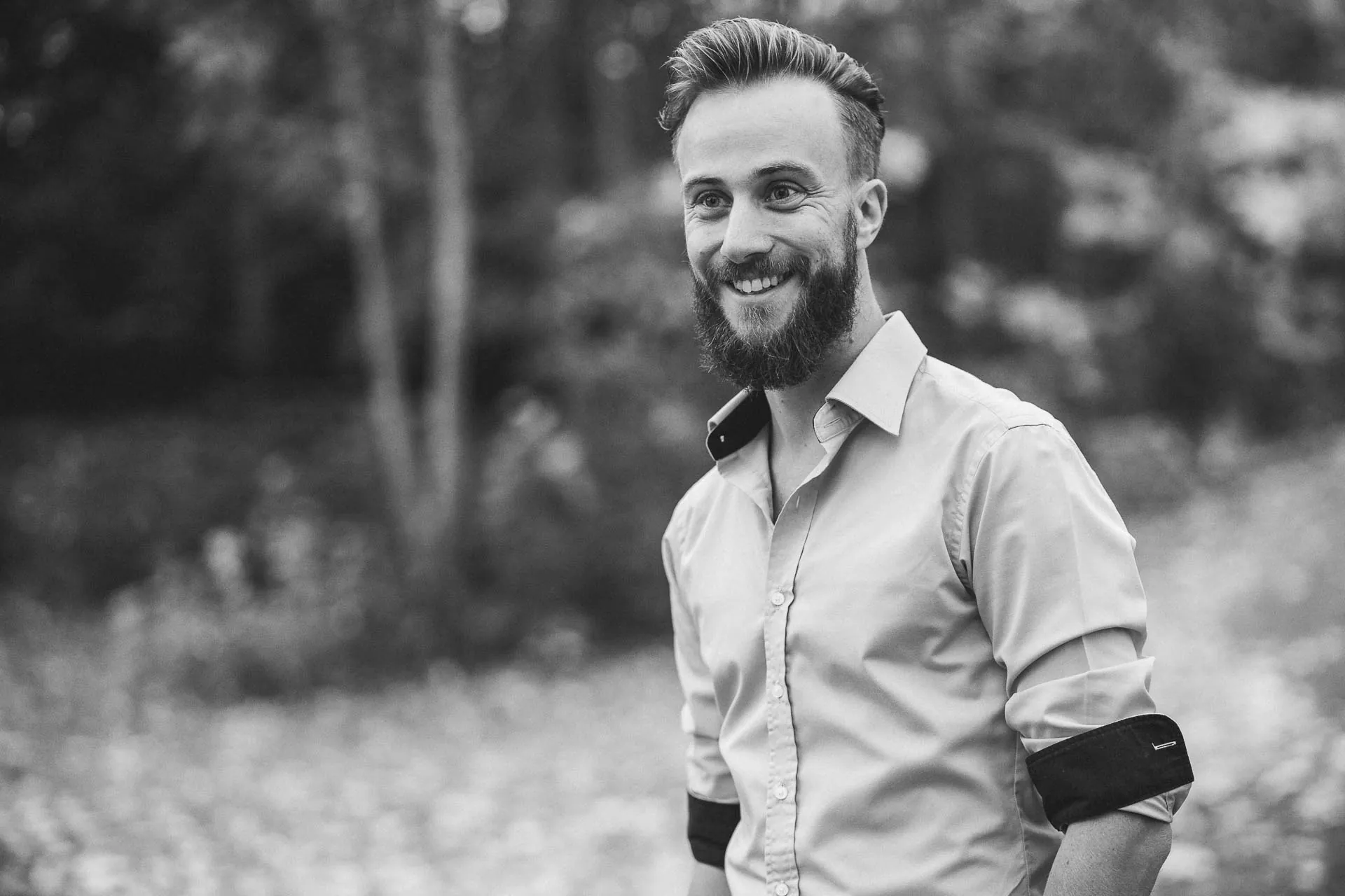 Christian Strohmayr lachend im Park, Schwarzweiß